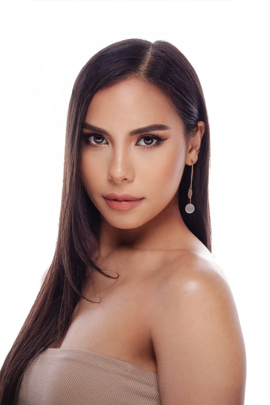 Close-up of a woman wearing the Aking Sinta 2-in-1 Capiz Shell Drop-Backed Studs; a polished gold stud sits on the earlobe, while a round, iridescent white Capiz shell disk hangs from the earring back, appearing to float just below the lobe.