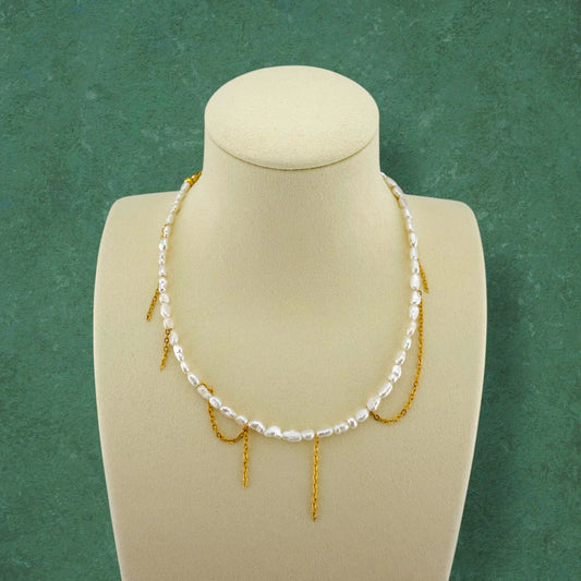 Kacey’s Asymmetrical Fringe Rice Pearl Necklace by Aking Sinta, displayed on a white jewelry bust to show the cascading, tiered fringe design.