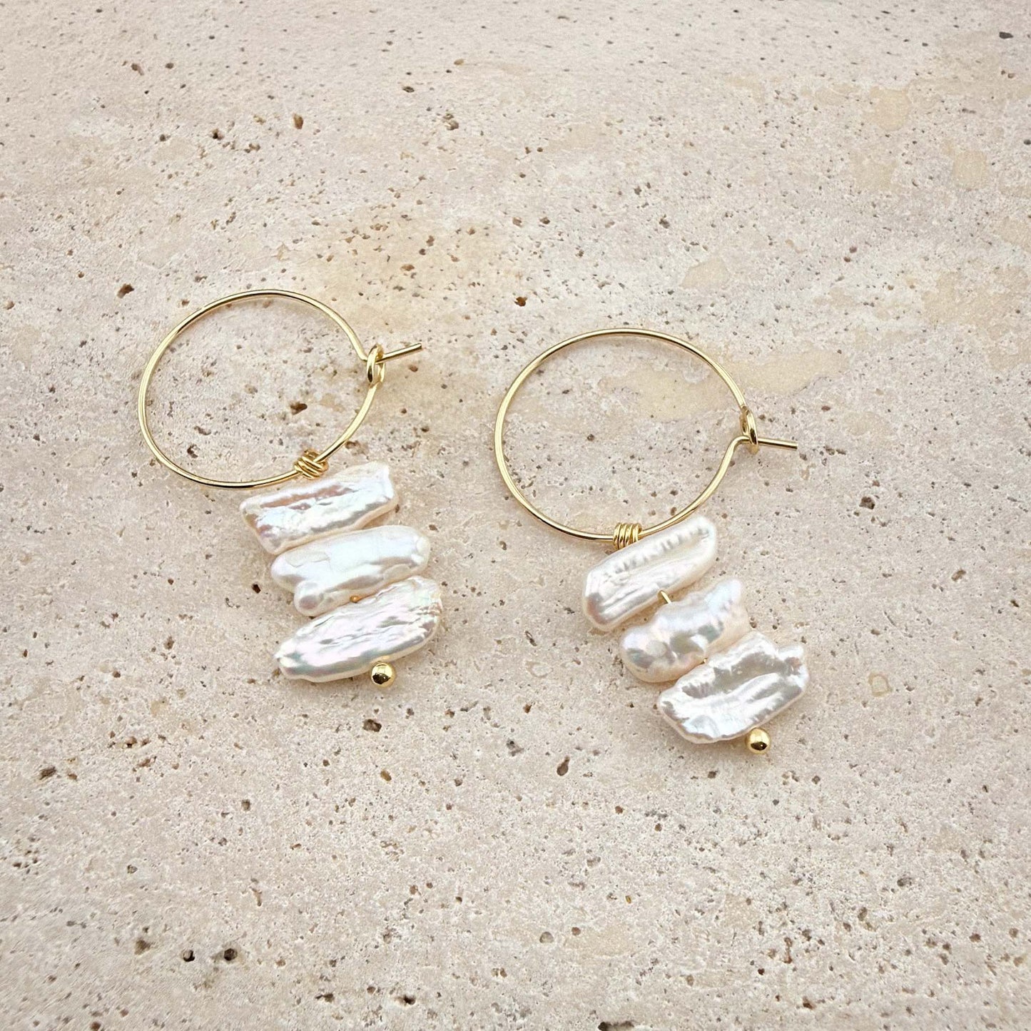 Side-by-side comparison of gold and silver Triple Flat Keshi Pearl hoop earrings on a white marble background.