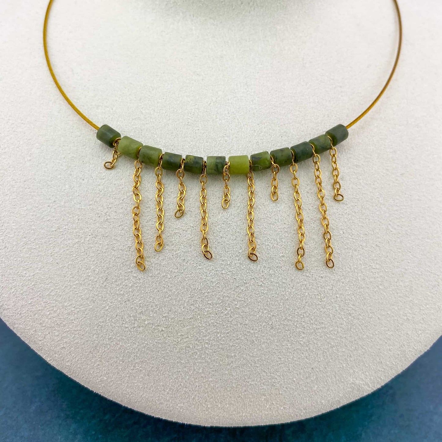 A macro close-up of the Aking Sinta asymmetrical fringe choker on a white bust; shows the fine detail of the gold chain attachments and the polished texture of the varied-length fringe drops.