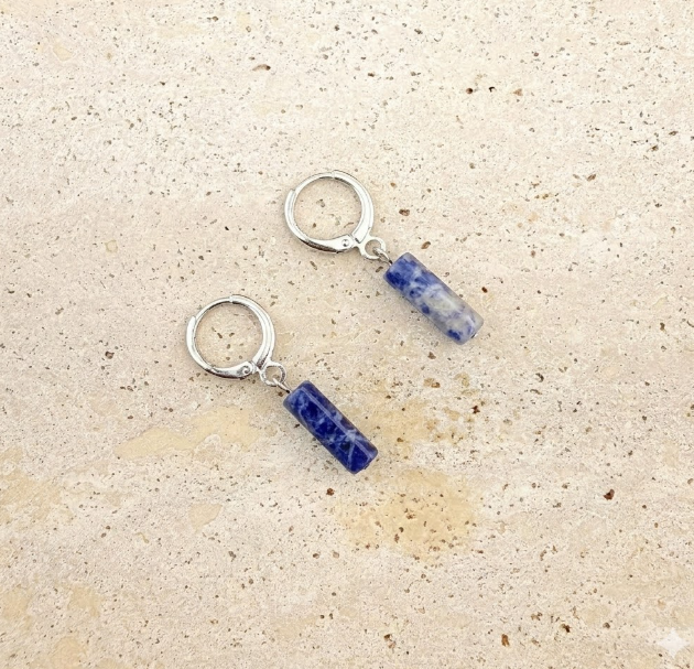 Silver-toned stainless steel blue watermelon column huggie earrings with all clasps closed, displayed on white marble.