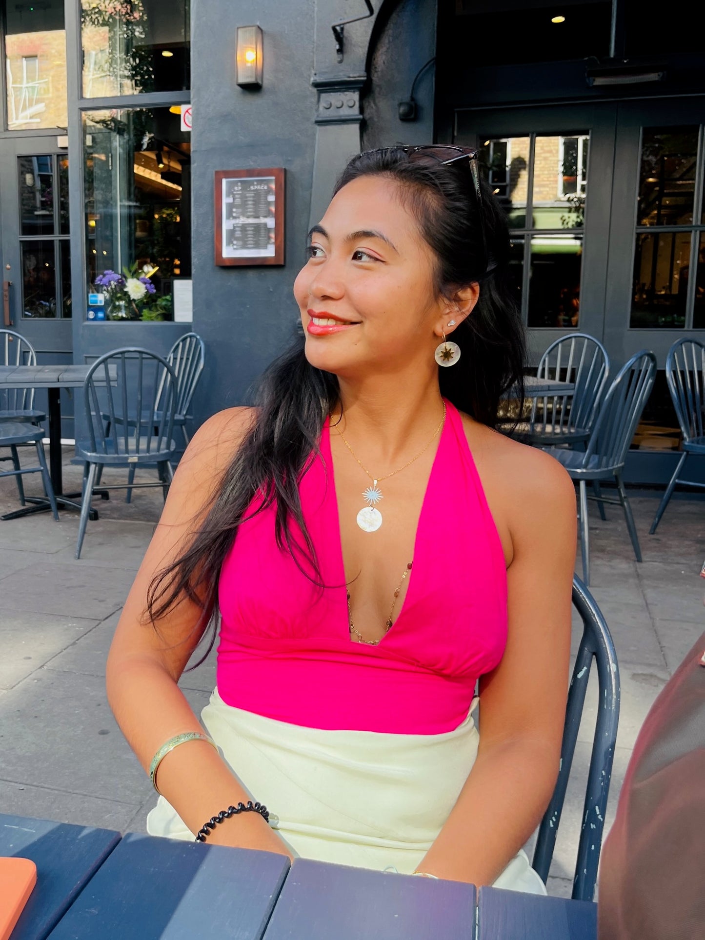 Model wearing Araw and Capiz Shell hoop earrings, showing elegant natural shell design and sun charm details in gold finish