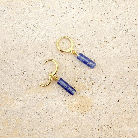 Gold blue watermelon column earrings on marble, with one huggie clasp open to show the secure hinge and post mechanism.