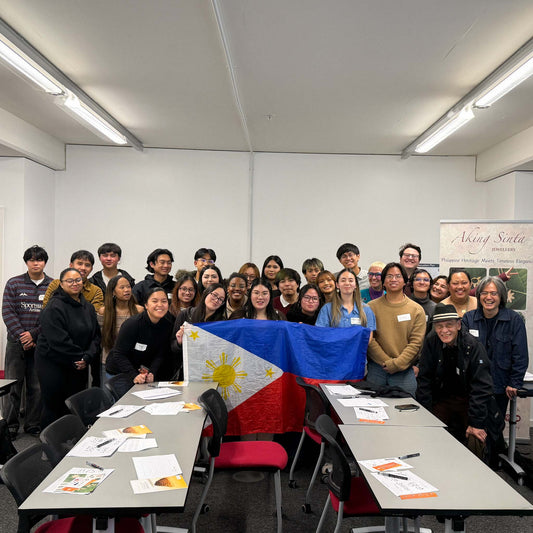 Group photo from Manchester’s first Baybayin workshop, with attendees and organisers gathered in a classroom holding the Philippine flag.