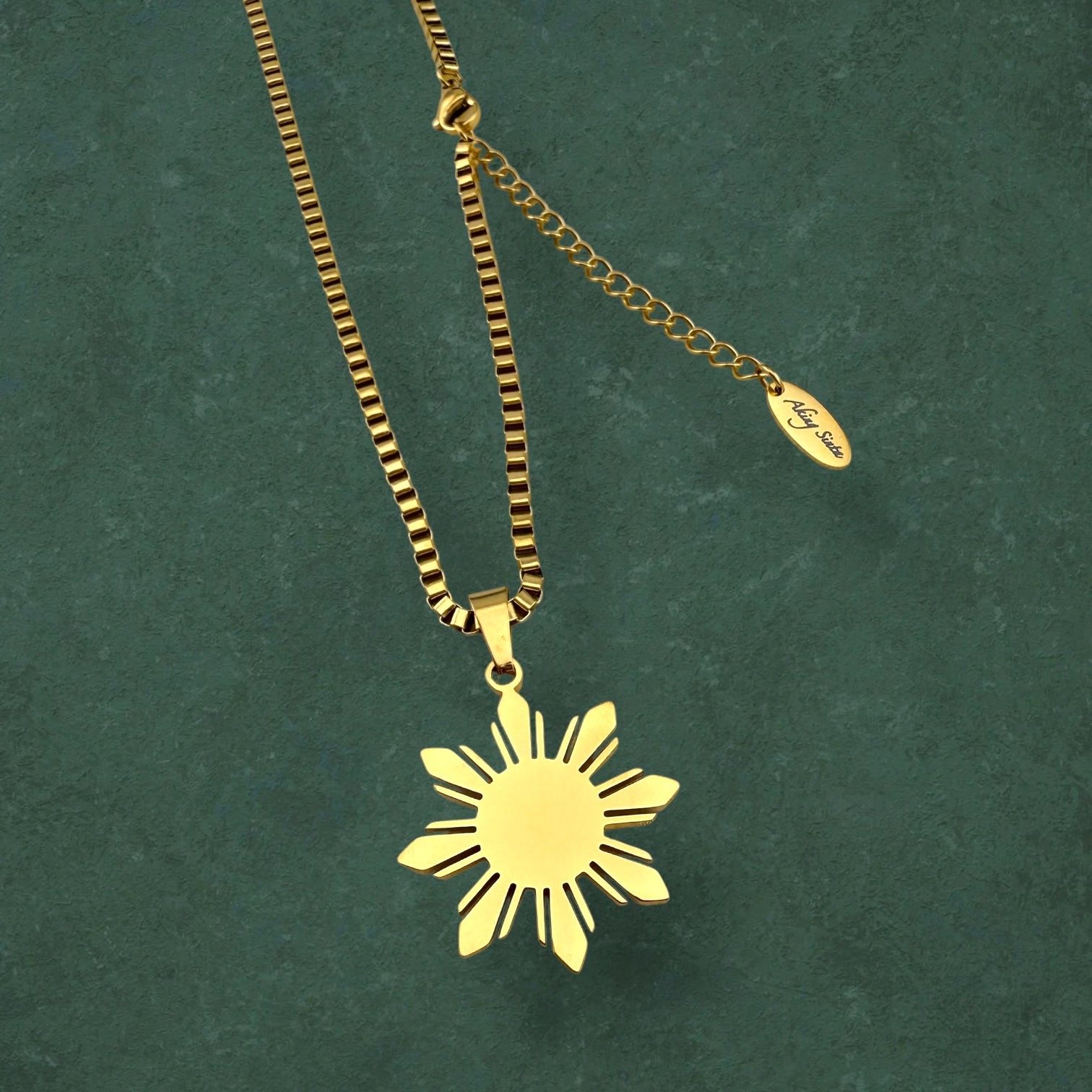 Aking Sinta Araw Chunky Box Chain Necklace in gold close-up on dark green marble background