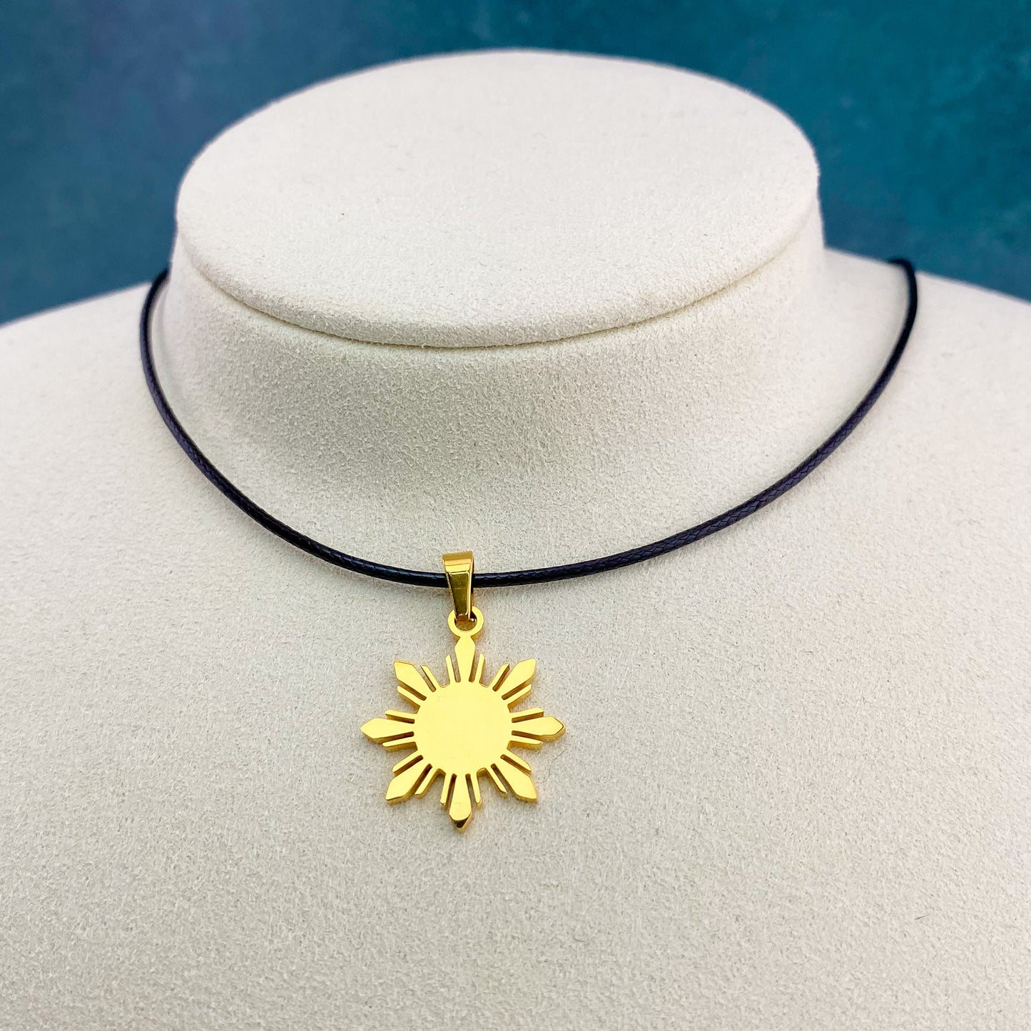 Aking Sinta Araw Cord Necklace with black cord and gold Araw sun charm displayed on neck-shaped jewellery holder, highlighting adjustable cord design and Philippine-inspired craftsmanship