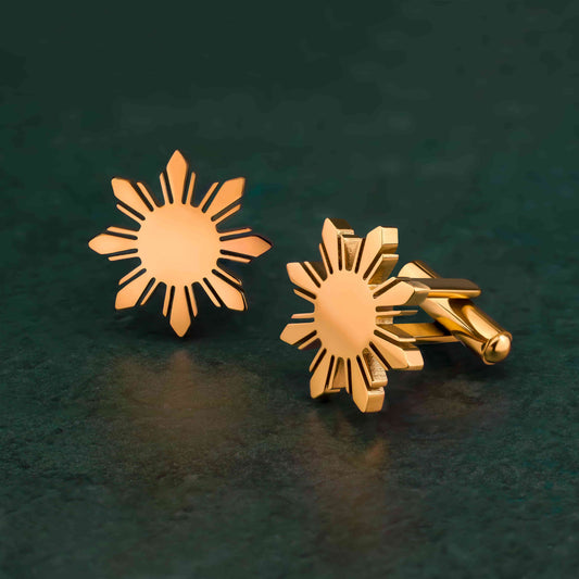 Aking Sinta Araw Cufflinks gold variant displayed on green background, highlighting 8-ray sun design and Philippine-inspired craftsmanship