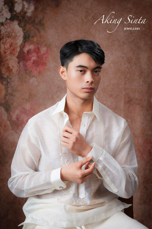 Aking Sinta Araw Cufflinks gold variant worn by model in white, fastened on polo sleeve at wrist, highlighting 8-ray sun design and Philippine-inspired craftsmanship