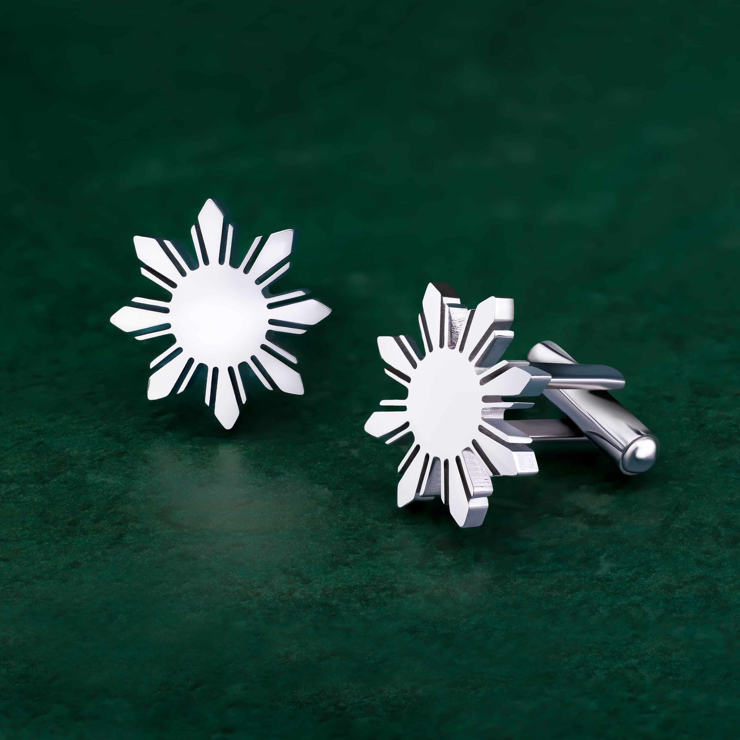 Aking Sinta Araw Cufflinks silver variant displayed on green background, highlighting 8-ray sun design and Philippine-inspired craftsmanship