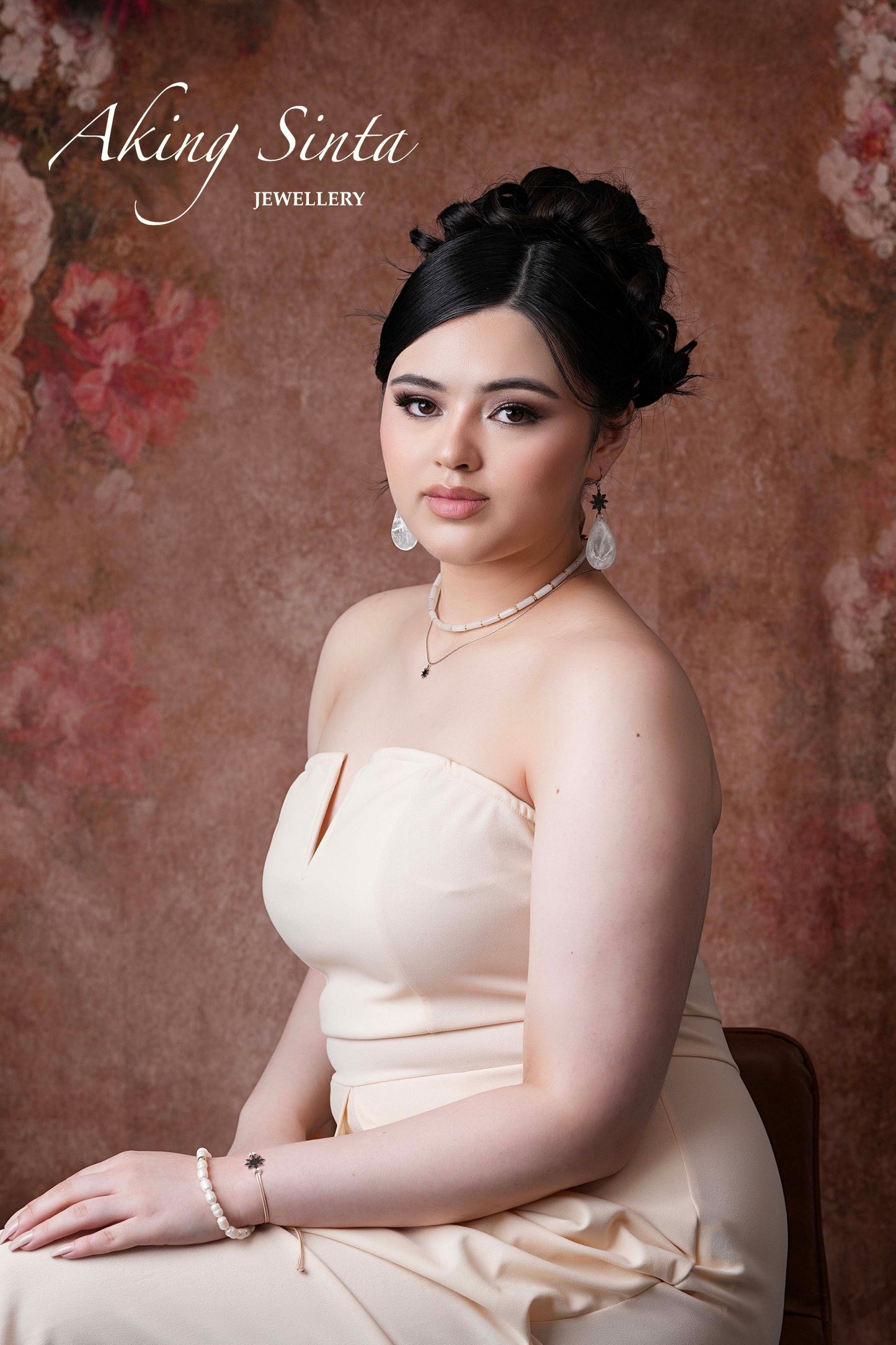 Aking Sinta Araw Friendship Bracelet in gold worn by woman sitting in elegant creamy gown, Philippine-inspired jewellery for diaspora abroad