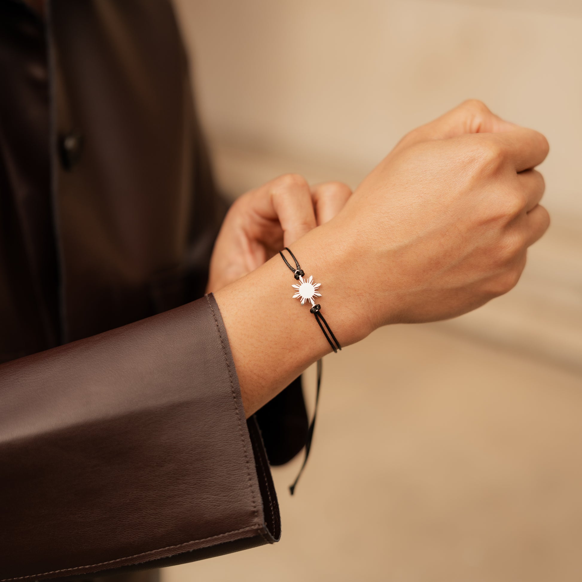 Aking Sinta Araw Friendship Bracelet in silver with black adjustable cord worn on man’s hand, Philippine-inspired jewellery for diaspora abroad