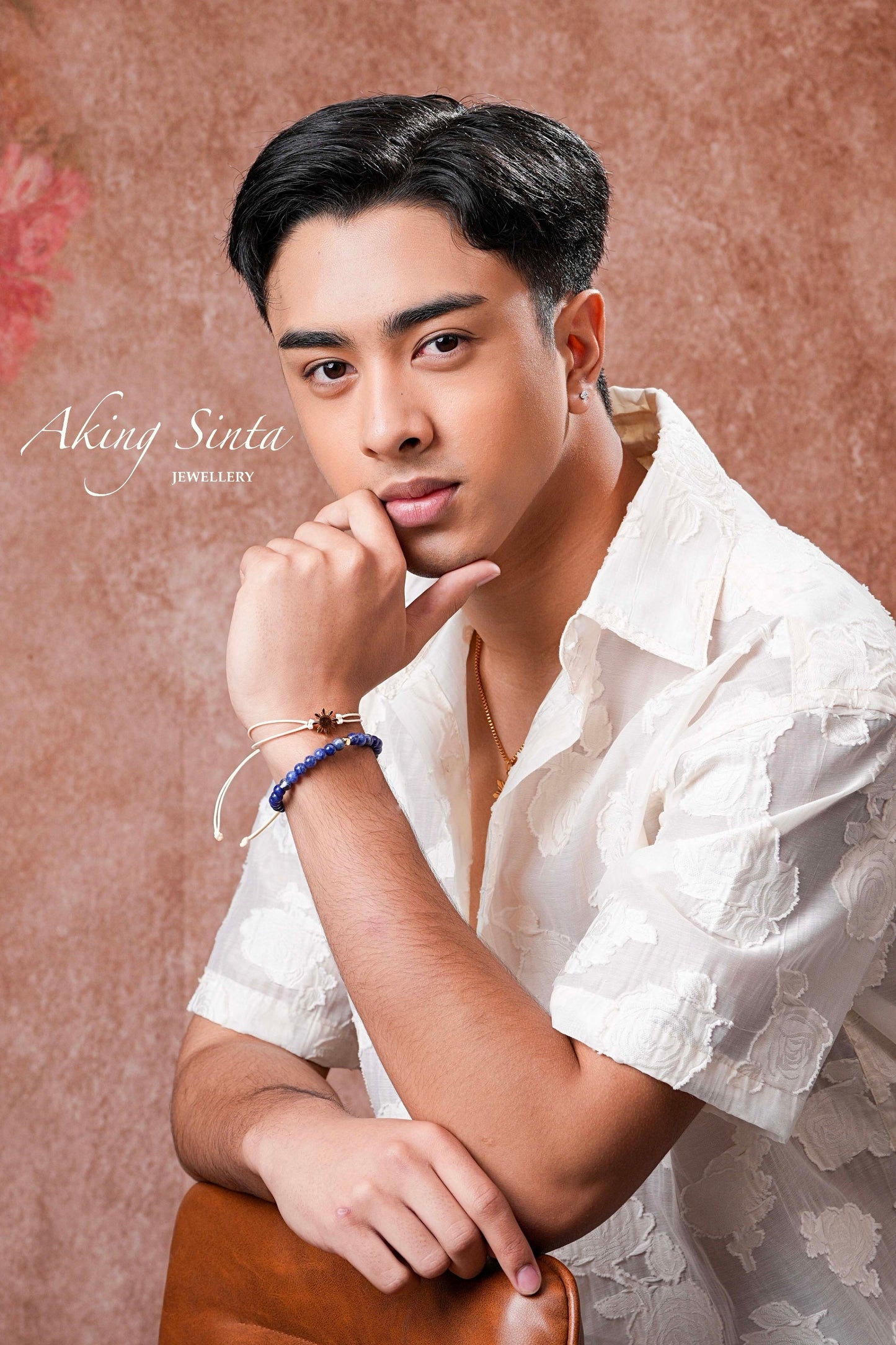 Aking Sinta Araw Friendship Bracelet in silver with white cord worn by man thinking with hands under chin, Philippine-inspired jewellery for diaspora abroad