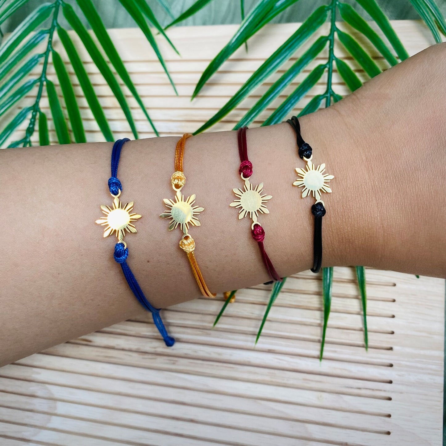 Aking Sinta Araw Friendship Bracelets in gold with blue, white, brown and other cords worn together on hand, Philippine-inspired jewellery for diaspora abroad