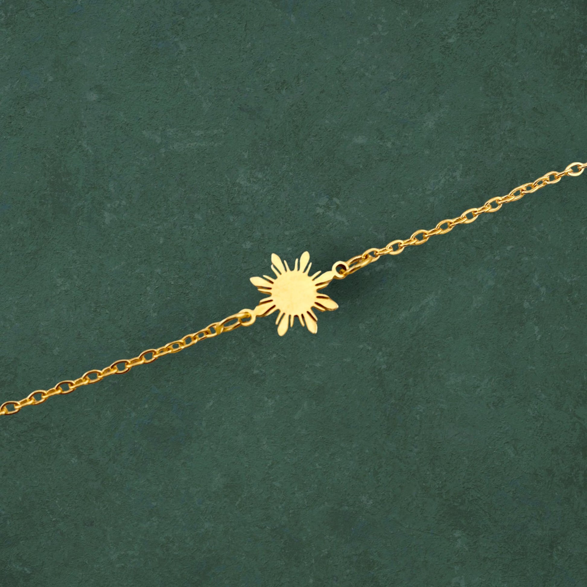 Aking Sinta Araw Minimalist Anklet gold variant shown in close-up on green background, highlighting delicate sun charm and clean, minimalist design