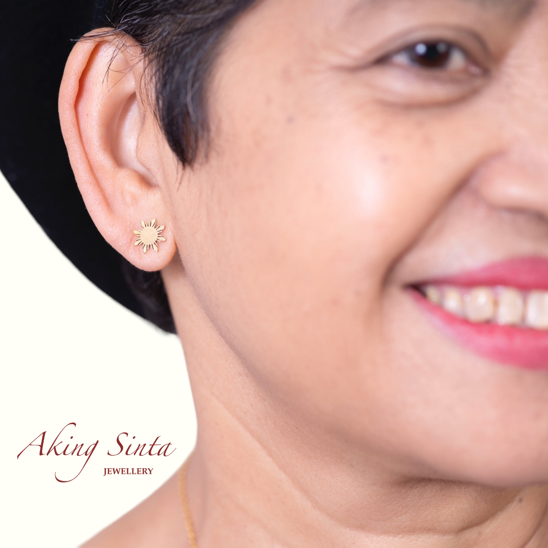 Aking Sinta Araw stud earring in gold worn on left ear by mother of the founder, highlighting 8-ray sun design and Philippine-inspired craftsmanship