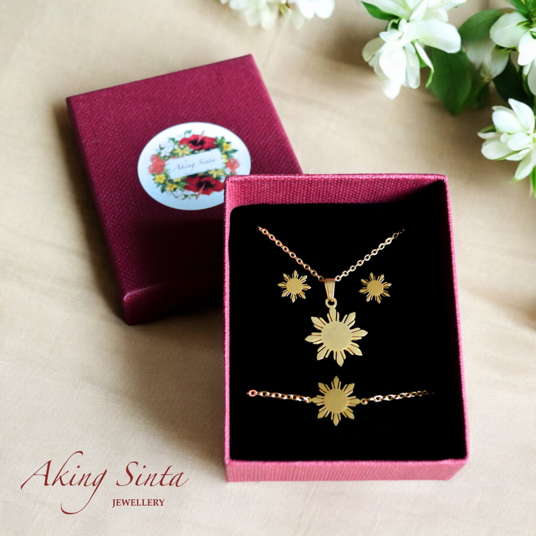 Aking Sinta Araw studs, necklace and bracelet gift set presented in gift box with sampaguita flower on white wooden surface, showcasing Philippine-inspired jewellery