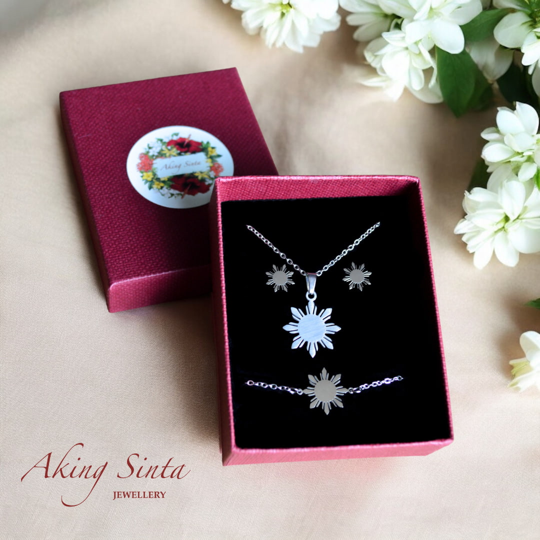 Aking Sinta Araw studs, necklace and bracelet gift set in silver presented in gift box with sampaguita flower on white wooden surface