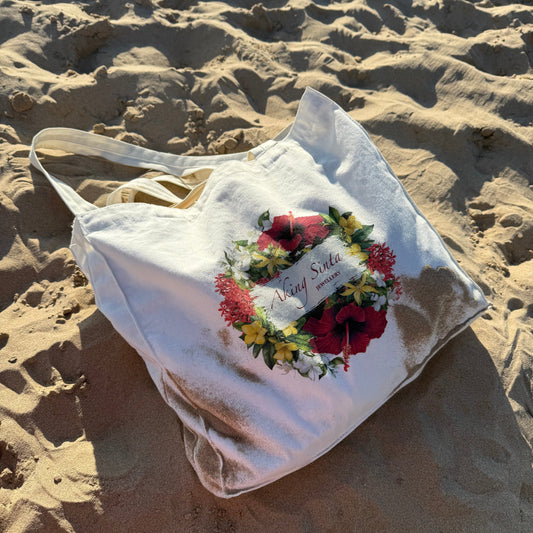 Aking Sinta ‘BET on Yourself’ Floral Tote Bag displayed on white sand beach, featuring Philippine blooms including gumamela, yellow bell, santan, sampaguita, ilang-ilang, with empowering mantra printed