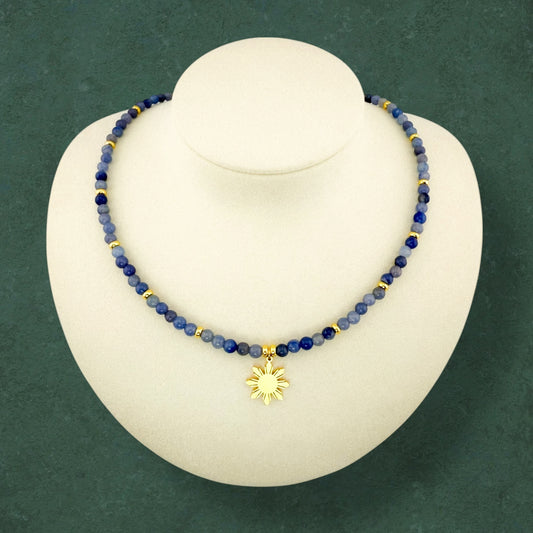 Aking Sinta Blue Aventurine beaded necklace with a gold 8-ray Araw sun charm, displayed on a professional white jewelry bust to show the length and drape of the piece.