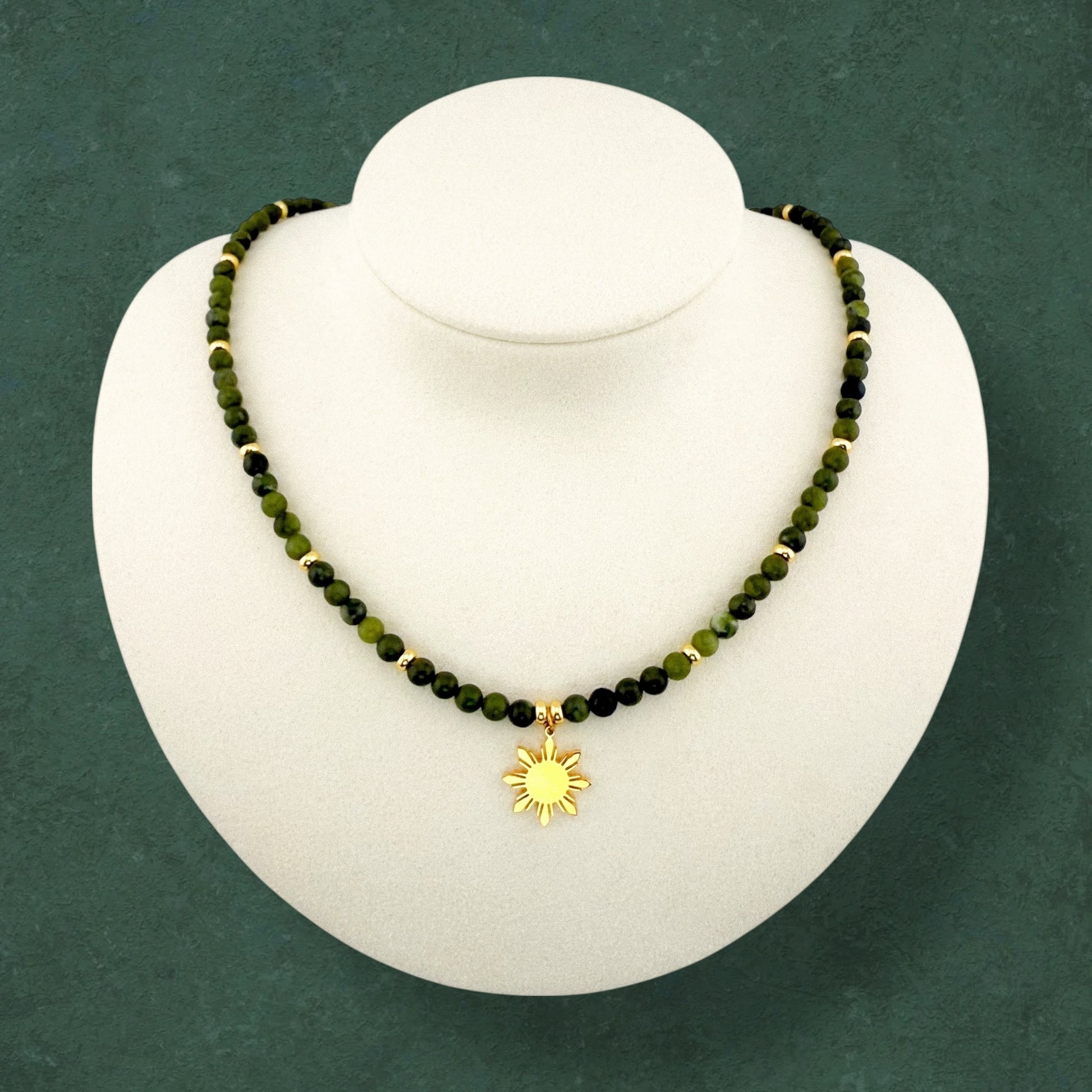 Aking Sinta Canadian Jade beaded necklace on a white display bust; featuring deep forest-green opaque gemstones accented with polished gold beads throughout the strand and a central gold 8-ray Araw sun charm; no extender.