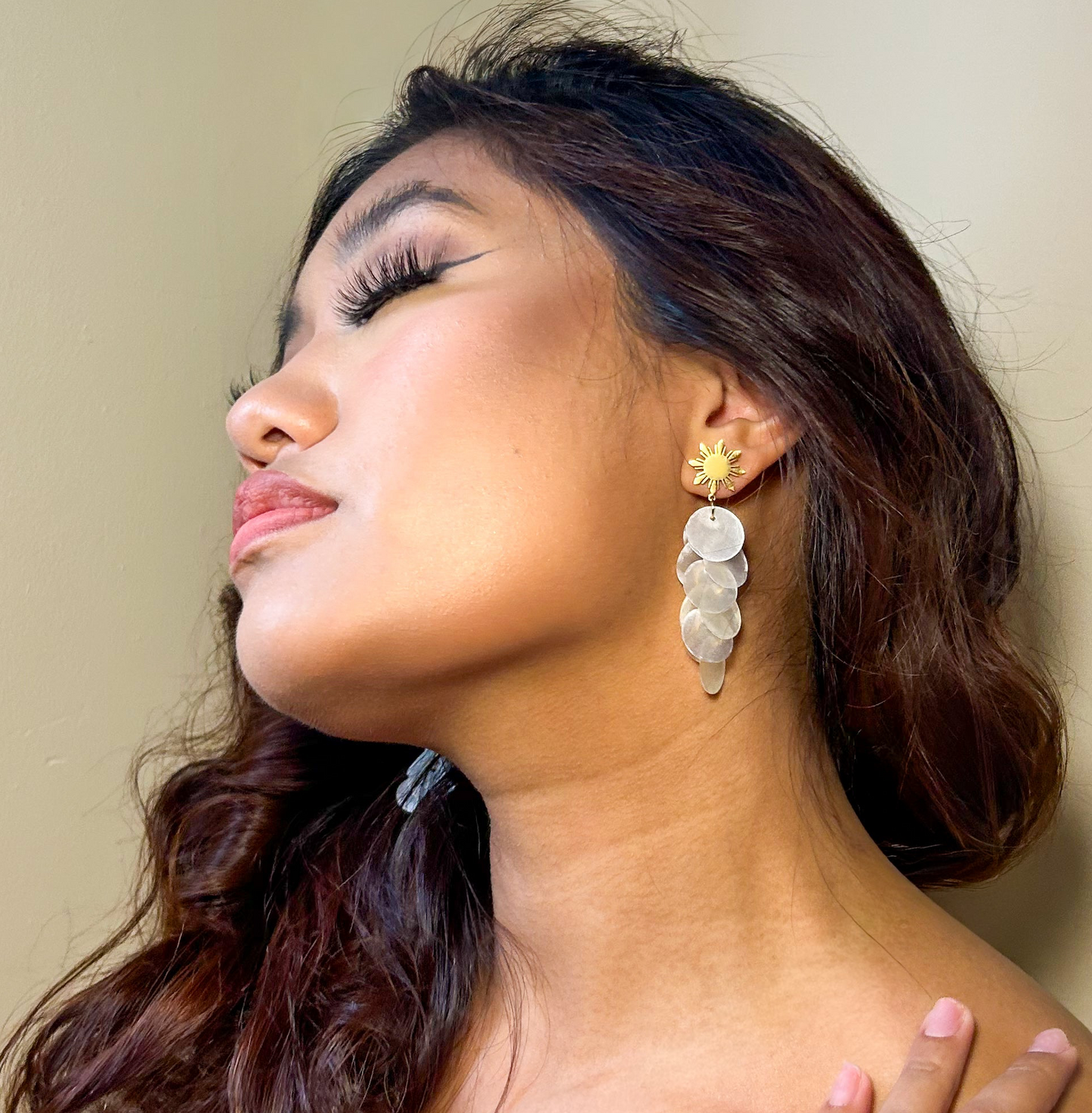 Aking Sinta Cascading Capiz Shell Araw Stud Earring worn on model’s left ear, highlighting lightweight design and Philippine-inspired craftsmanship