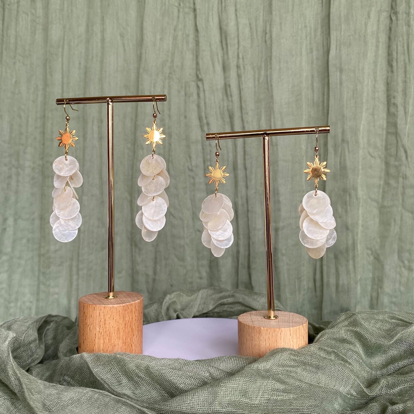 Aking Sinta Cascading Capiz Shell Hook Earrings with Araw sun charms displayed as full pair on two silver rods, highlighting lightweight design and Philippine-inspired craftsmanship