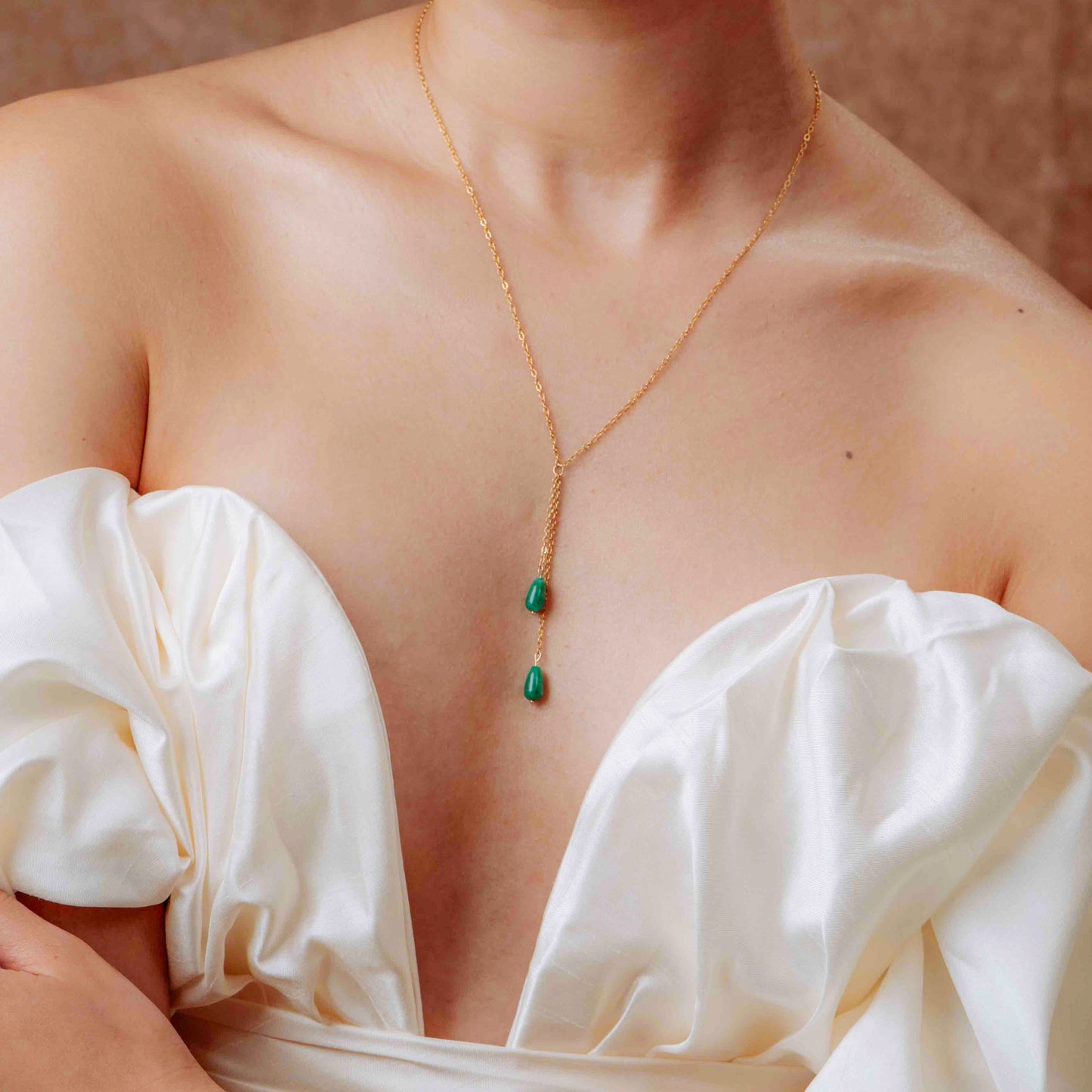 Close-up of Aking Sinta Dainty Teardrop Jade Chain Necklace resting on model’s cleavage, highlighting teardrop jade pendant and delicate chain design