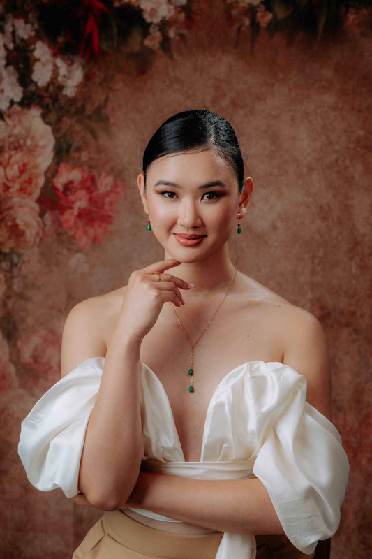 Aking Sinta Dainty Teardrop Jade Chain Necklace worn by woman in white dress, right hand on chin, showcasing teardrop jade pendant and delicate chain