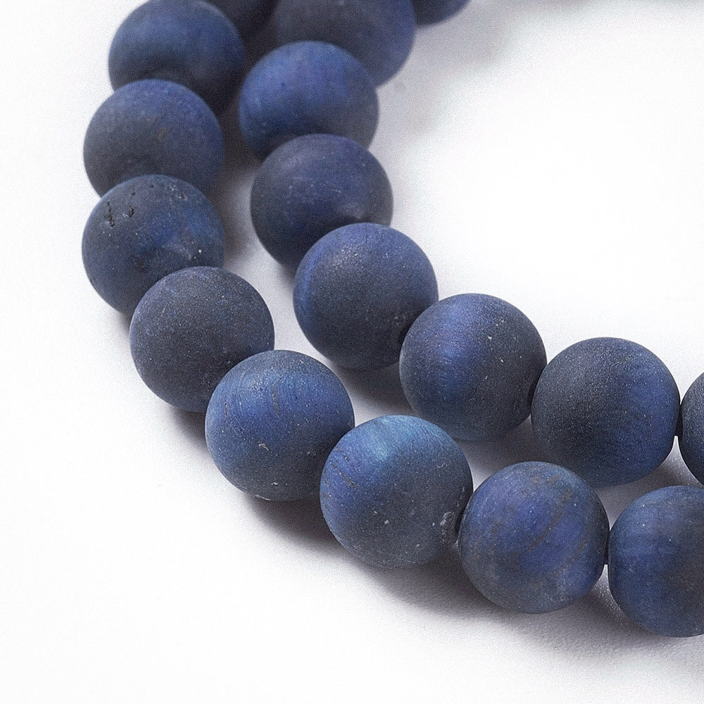 Macro close-up of Aking Sinta dark blue Tiger Eye beads; showing the midnight navy color and the natural silky light-reflecting "cat's eye" shimmer.