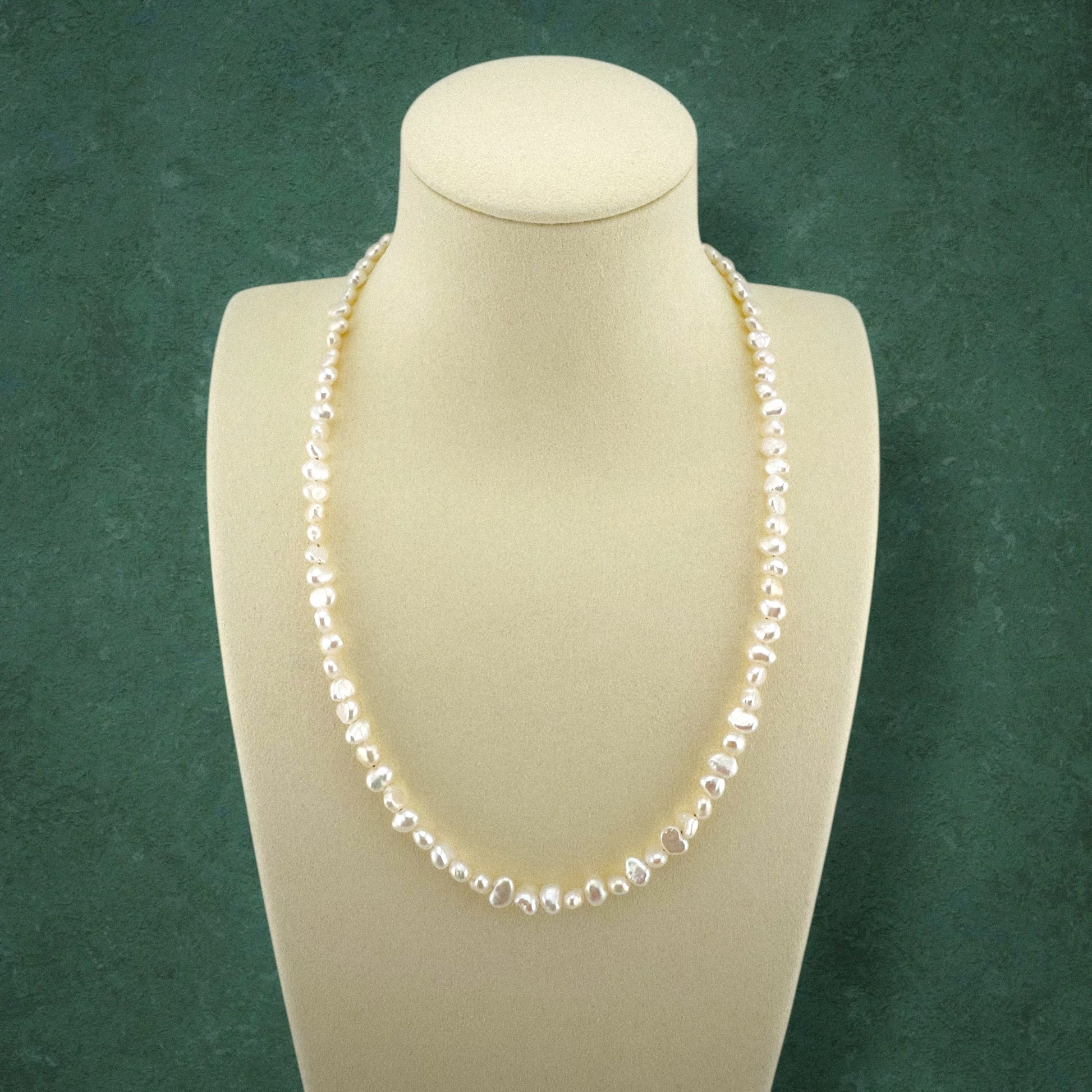 Aking Sinta statement necklace featuring large, elongated Baroque pearls with a high-gloss luster, displayed on a tall white jewelry bust.