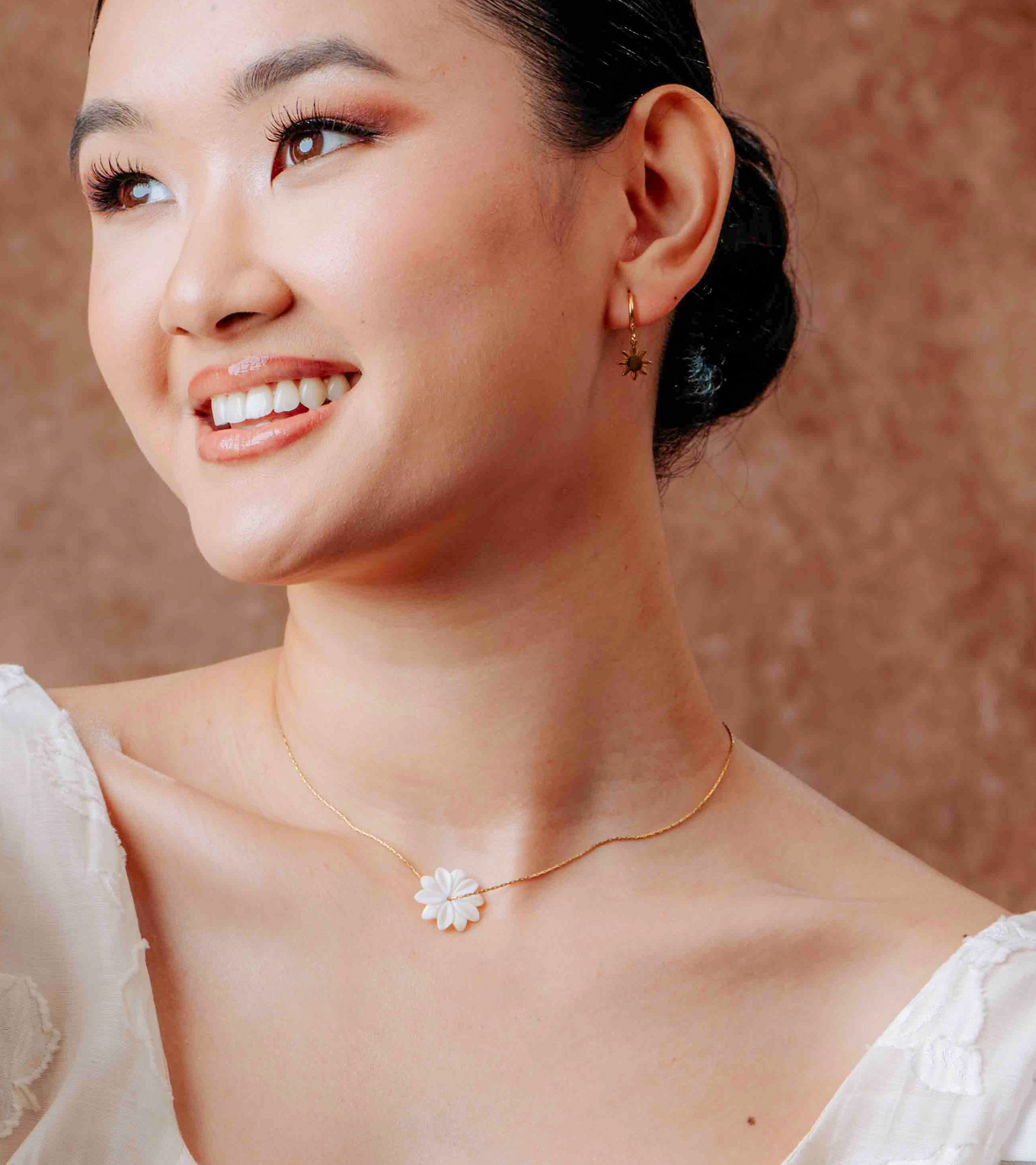 Model wearing the Aking Sinta Floating Sampaguita Necklace; features a dainty, hand-carved Mother of Pearl jasmine bud pendant on a thin gold chain.