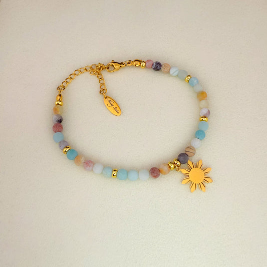 Aking Sinta Flower Amazonite beaded bracelet featuring light blue, sky blue, and cream gemstones with natural gold inclusions, accented by a gold 8-ray Araw sun charm and a gold extender chain with an engraved "Aking Sinta" teardrop tag; on a white background.