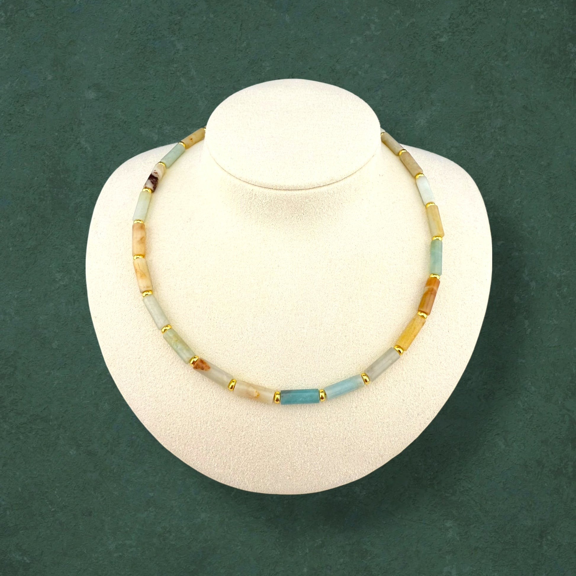 Aking Sinta Flower Amazonite column necklace with long tube beads in mint green and cream, displayed on a white bust against a dark green background.