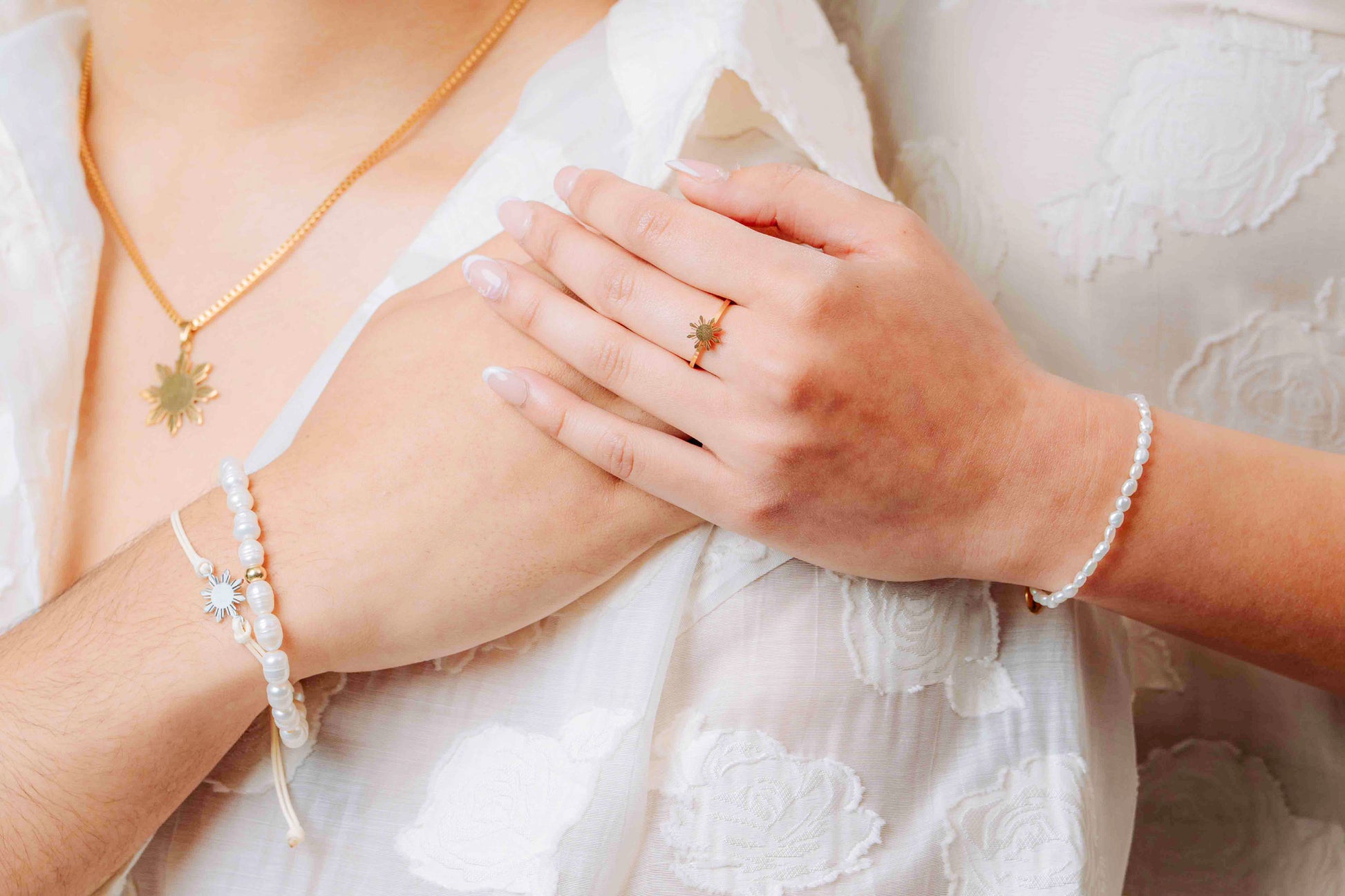 Aking Sinta Freshwater Pearl Stretch Bracelet worn on man’s hand, held by woman standing behind, photography focused at chest level, highlighting natural stone beads and Araw charm