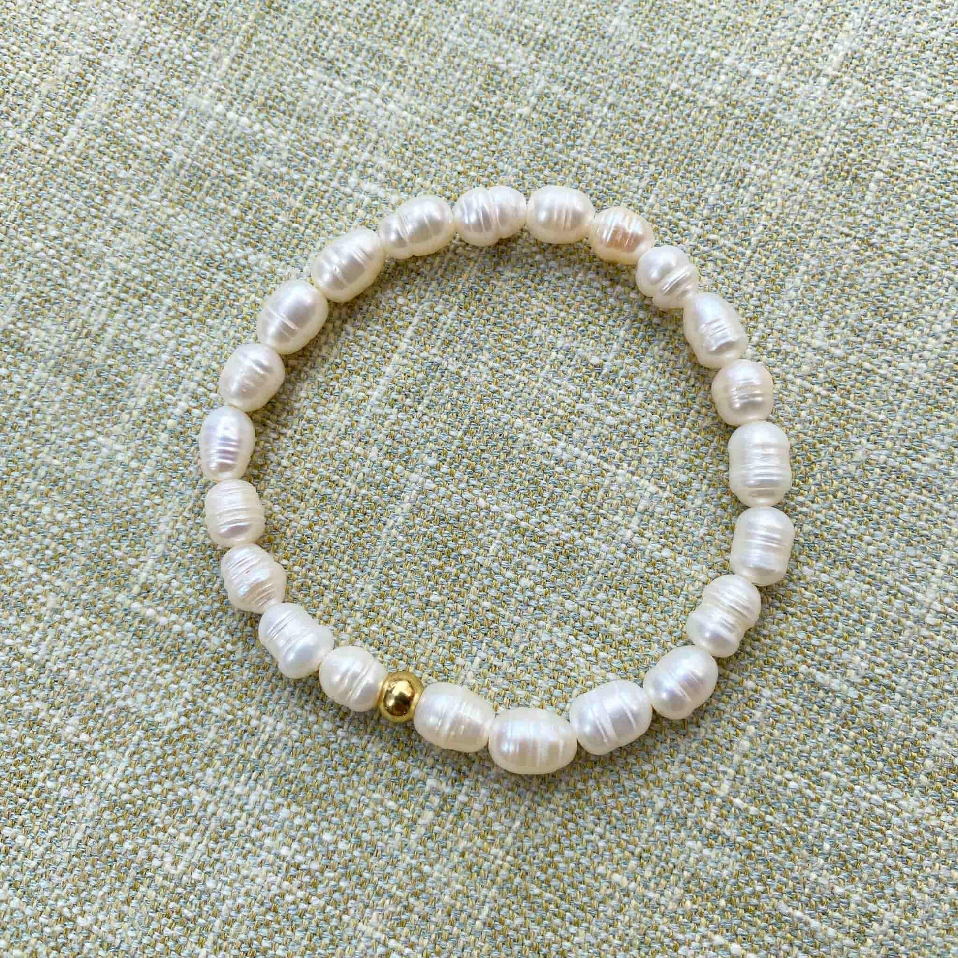 Aking Sinta Freshwater Pearl Stretch Bracelet with white beads, no charm, displayed on woven textured background, highlighting natural stone beads and stretch design