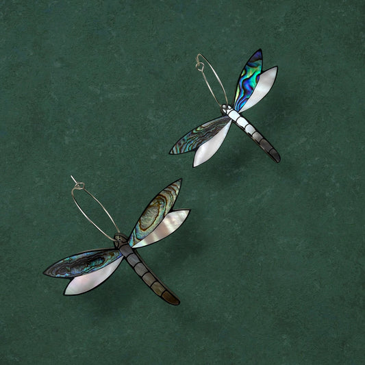Aking Sinta gold Tutubi (Dragonfly) hoop earrings with intricate wing details, displayed against a moody dark green background.