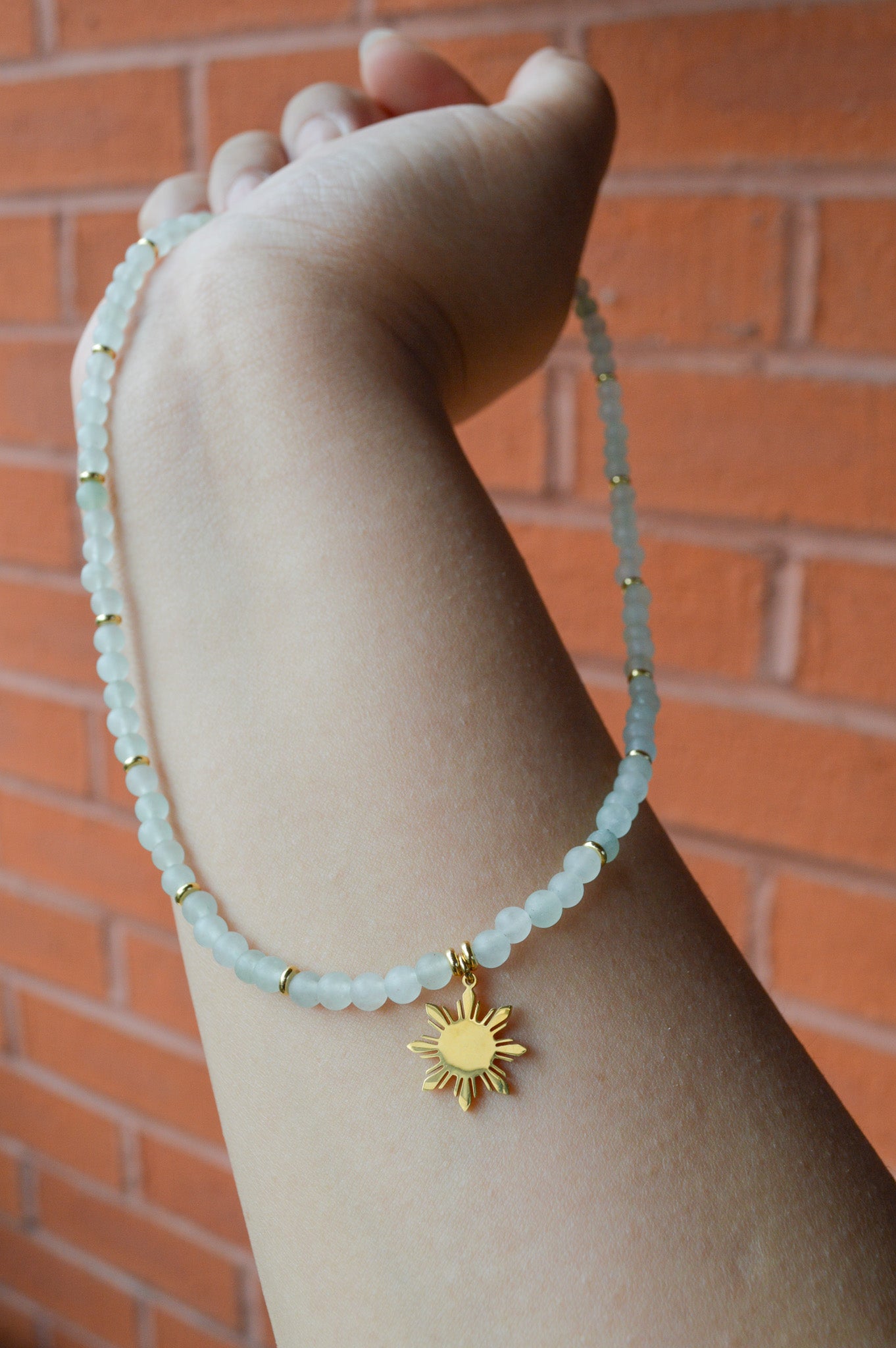 Aking Sinta Green Aventurine Necklace with Araw sun charm held in hand, highlighting natural green stone beads and Philippine-inspired design