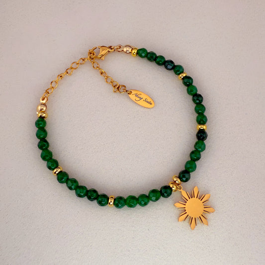 A strand of round Green Jade beads featuring a central polished gold "Araw" (sun) charm and a gold extender chain with a lobster clasp, displayed on a solid white background.