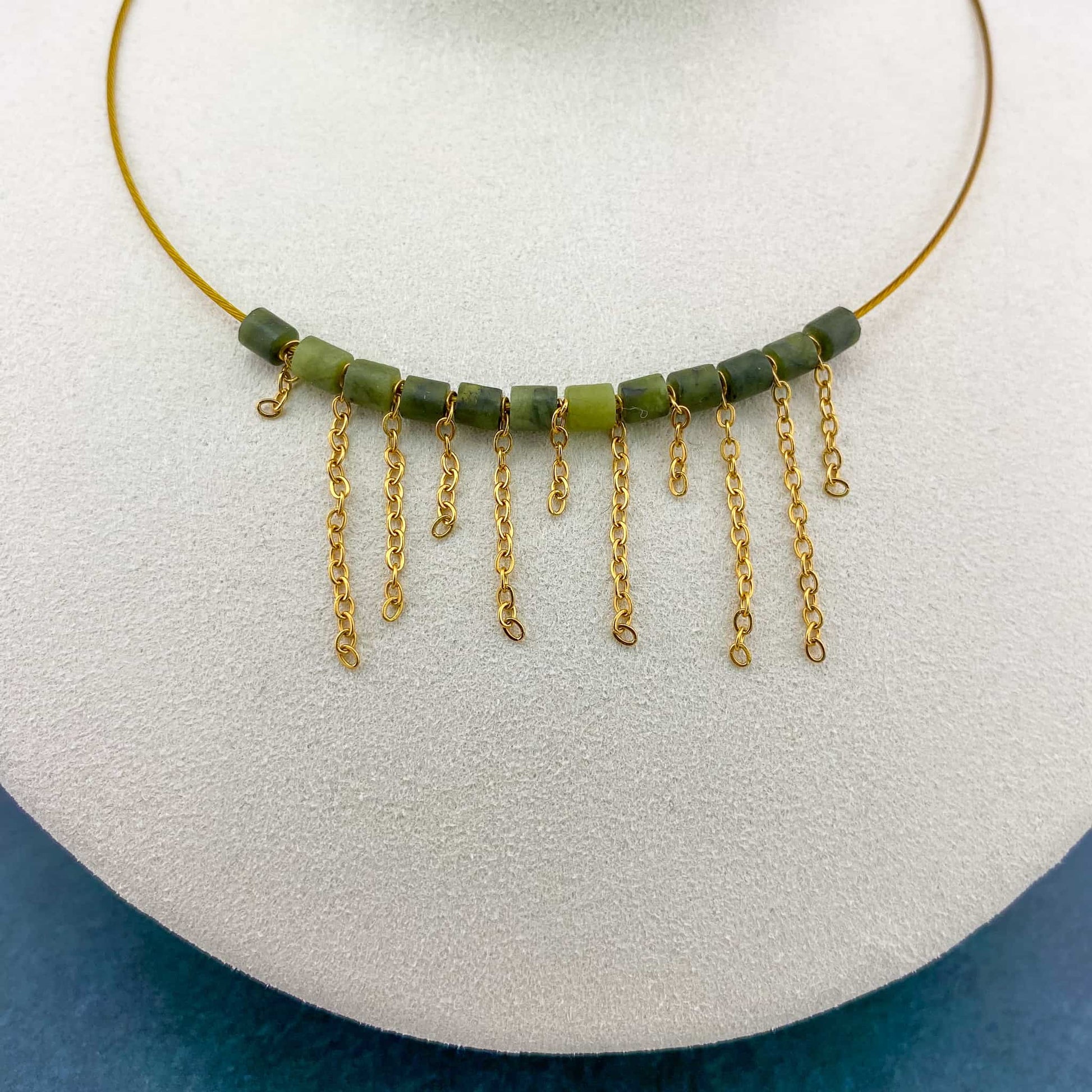 A macro close-up of the Aking Sinta asymmetrical fringe choker on a white bust; shows the fine detail of the gold chain attachments and the polished texture of the varied-length fringe drops.