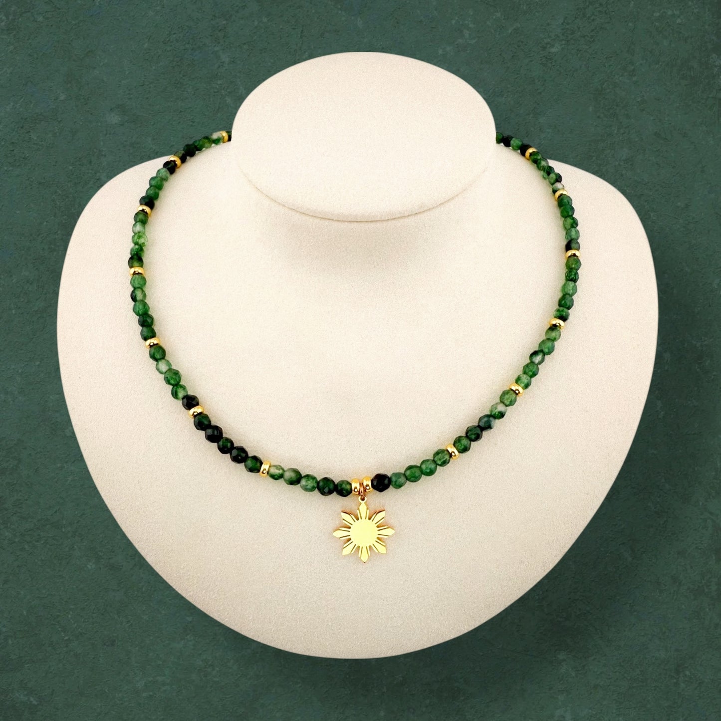 Aking Sinta Malaysian Jade beaded necklace on a white display bust; featuring translucent, vibrant candy-green gemstones accented with polished gold beads and a central gold 8-ray Araw sun charm