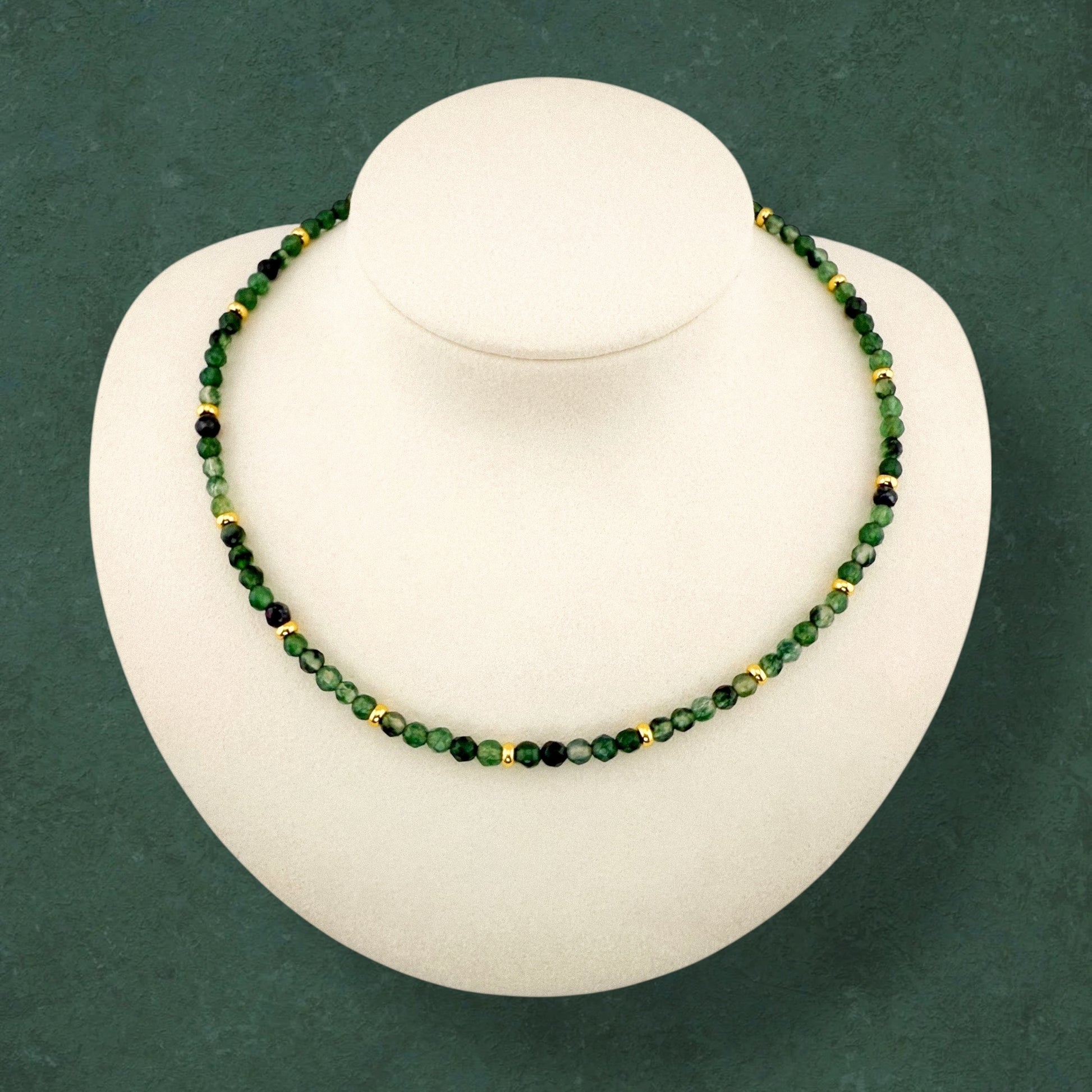 A minimalist Aking Sinta Malaysian Jade beaded necklace displayed on a white bust; featuring a continuous strand of translucent, vibrant candy-green gemstones accented with small polished gold beads