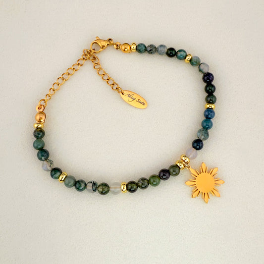 An Aking Sinta Moss Agate beaded bracelet featuring deep forest-green translucent stones and a signature gold 8-ray Araw sun charm, displayed on a crisp white background.