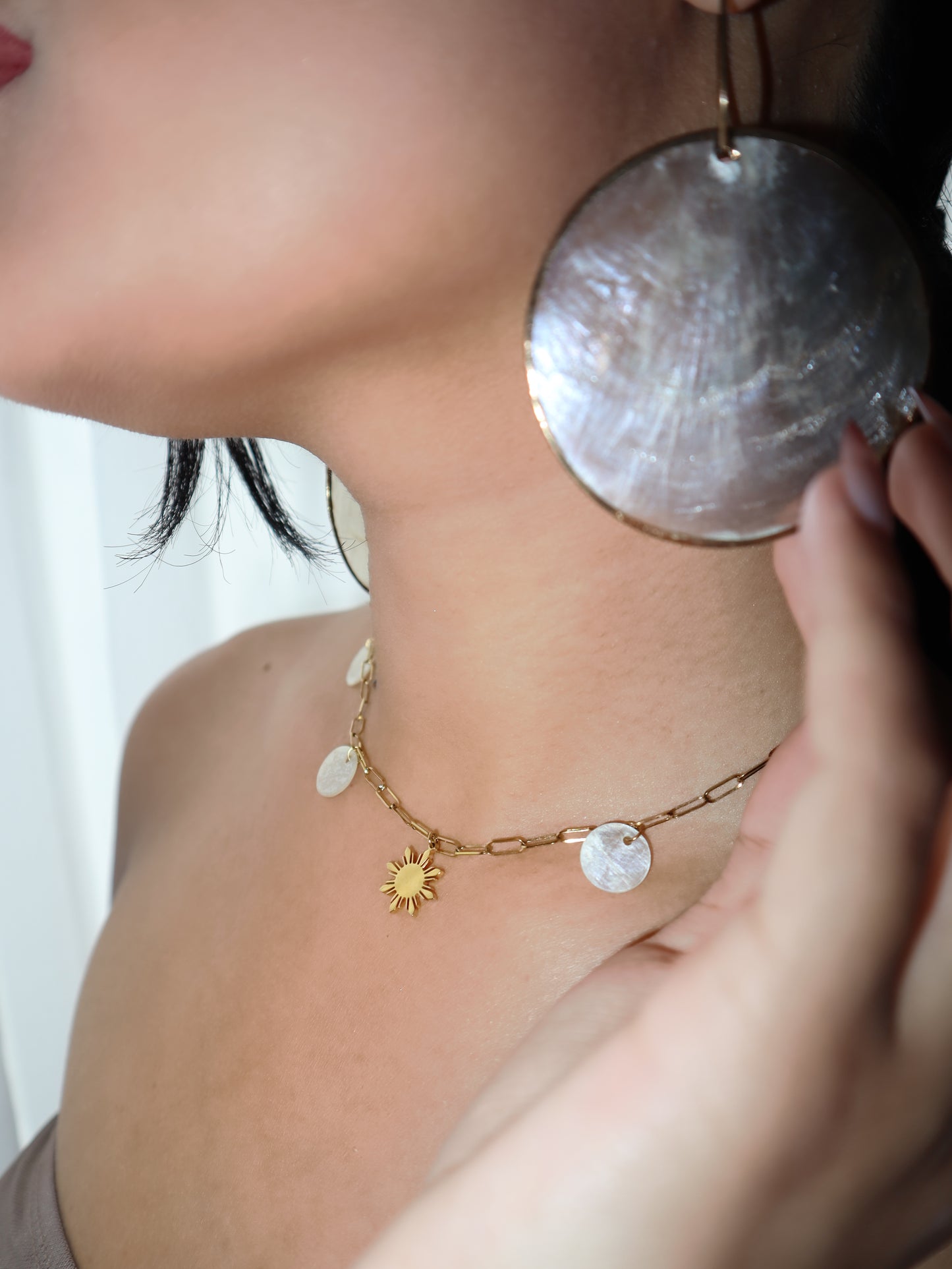 Aking Sinta Paperclip Chain Necklace with Araw sun and Capiz Shell charms worn on a woman’s neck, highlighting delicate design and Philippine-inspired craftsmanship