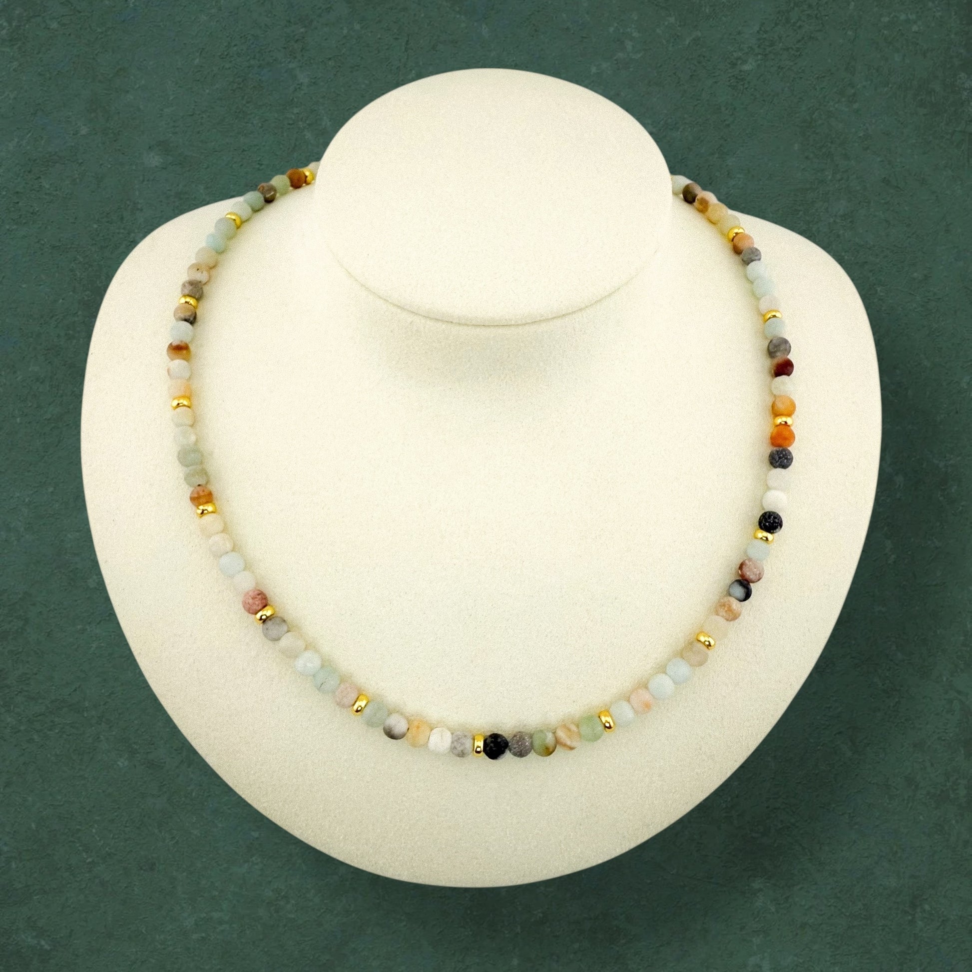 A plain Aking Sinta Flower Amazonite beaded necklace without a charm, displayed on a white jewelry bust; featuring cream, light blue, and speckled green beads with small gold bead accents.