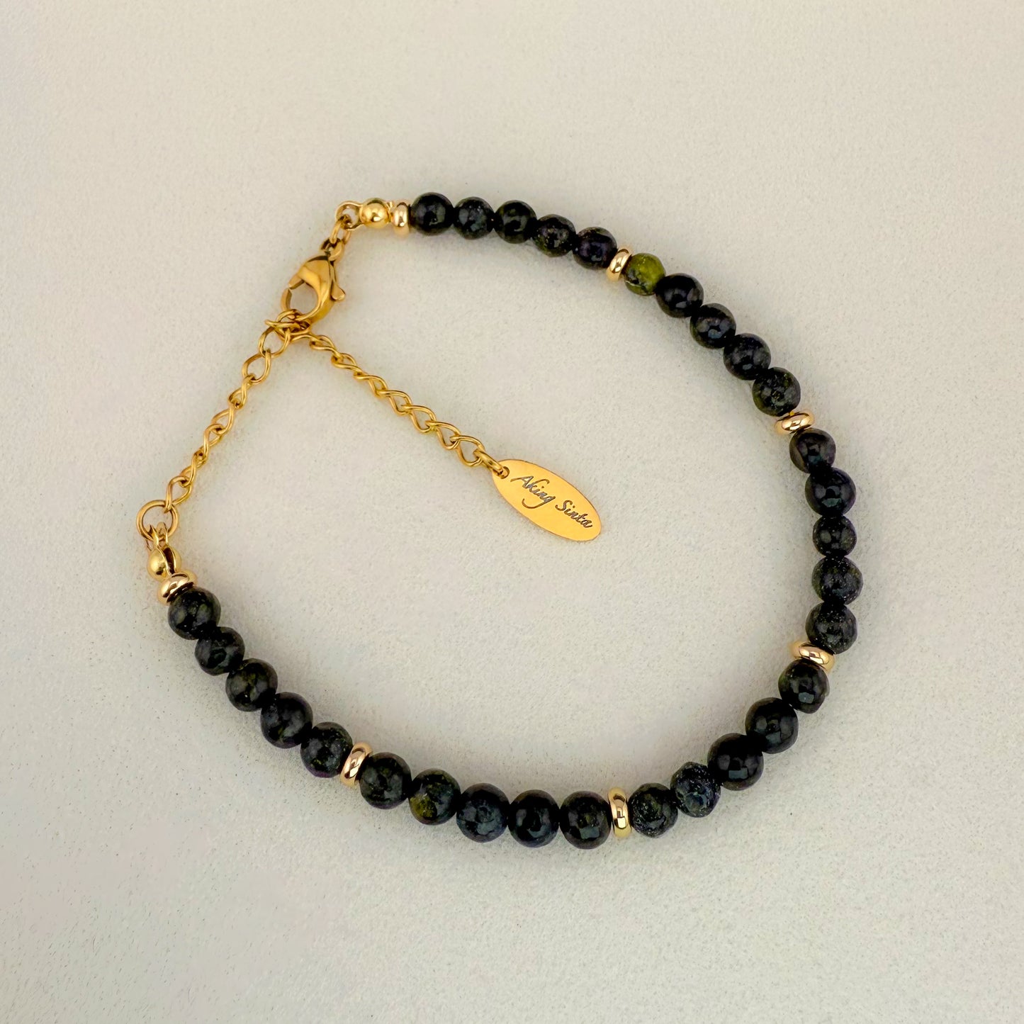 A minimalist Aking Sinta Serpentine beaded bracelet without a charm, featuring translucent lime and olive green gemstones with soft natural clouding; finished with a gold extender chain and a teardrop tag engraved with "Aking Sinta."