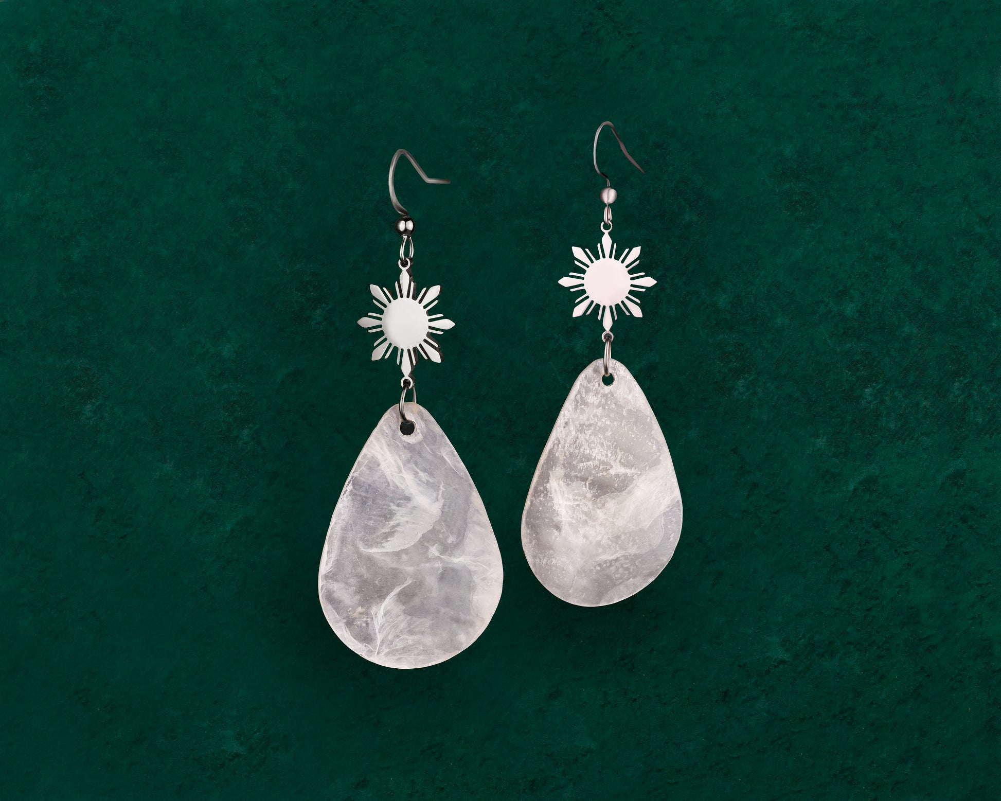 Aking Sinta Teardrop Capiz Shell Hook Earrings with Araw charms in silver on dark green background
