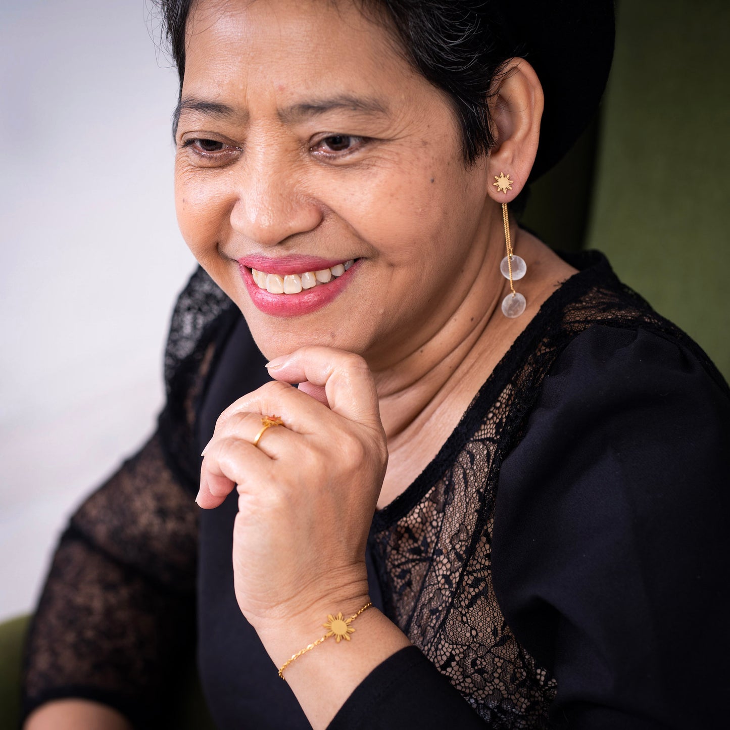 The founder’s mother wearing the Araw minimalist gold sun bracelet with a black outfit, showcasing elegant and ageless jewelry styling for everyday luxury