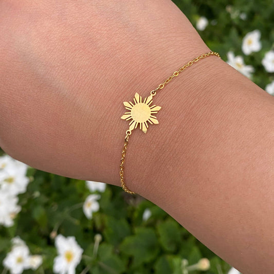 Araw minimalist bracelet with Philippine sun charm in 18K gold plated stainless steel, worn on hand as modern Filipino jewelry