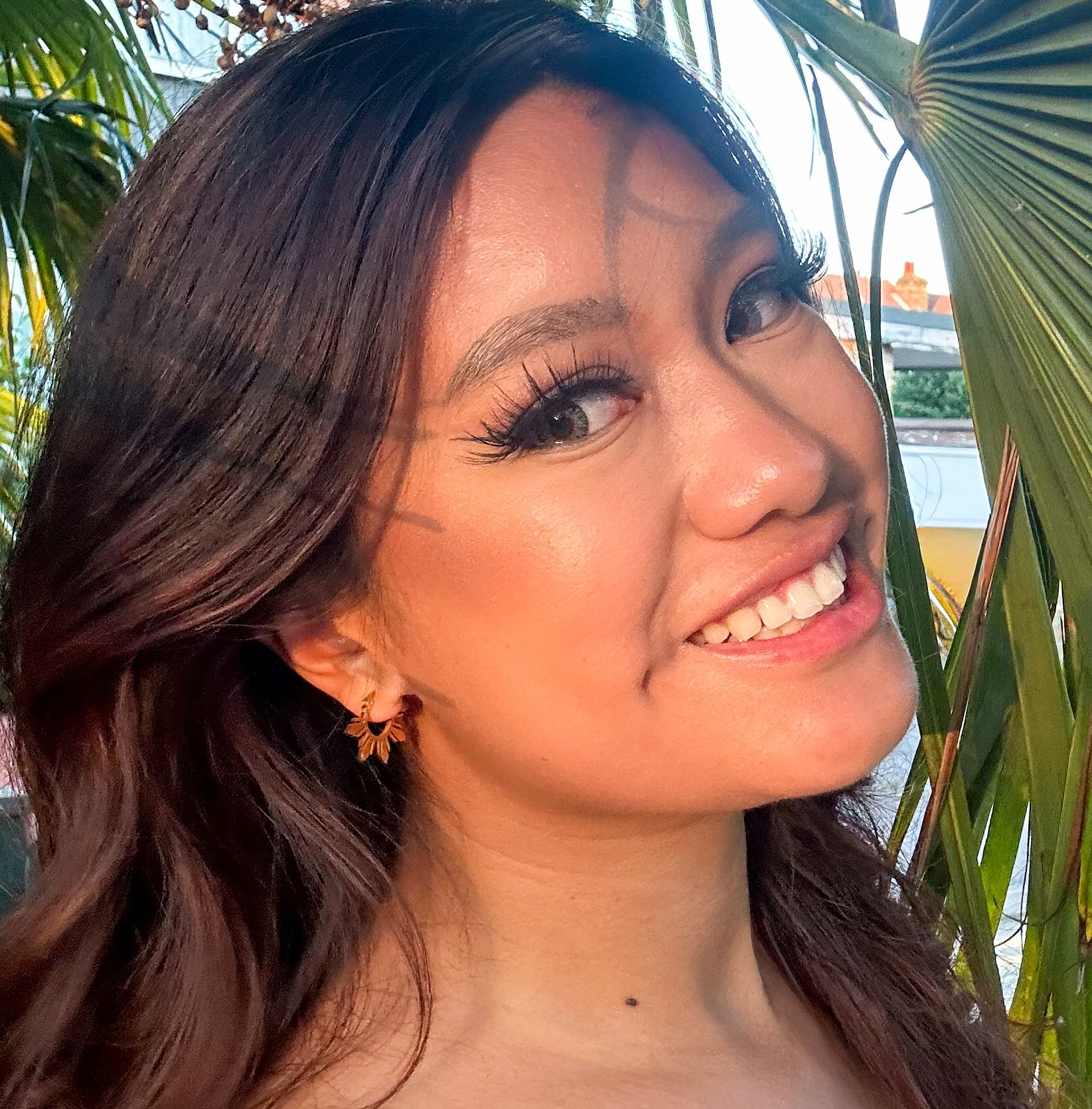 Close up side profile of a woman wearing the gold Araw 5-ray sun hoop earrings, showcasing the dainty celestial design and modern jewelry fit.