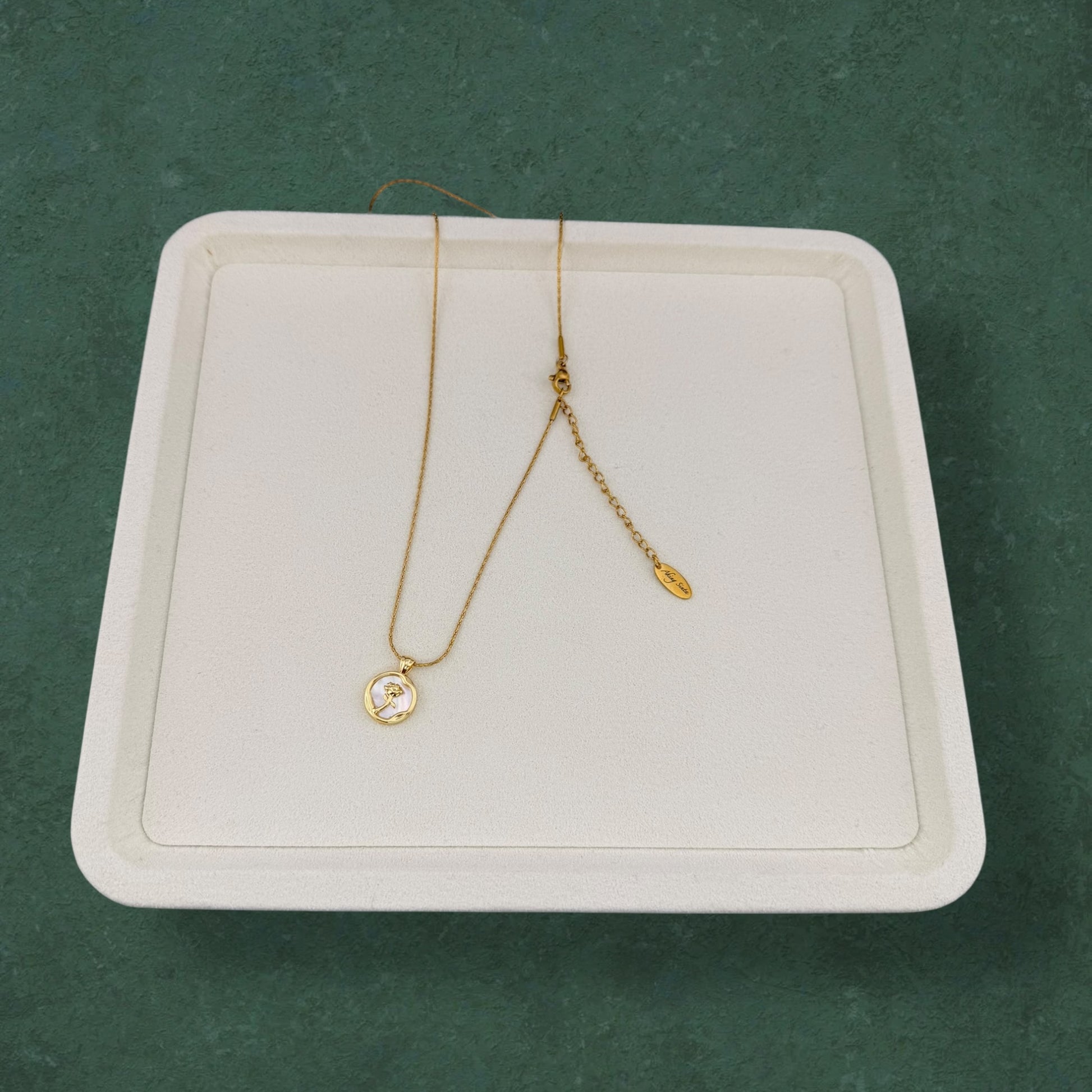 Rose and Mother of Pearl necklace arranged on elegant tray, featuring floral pendant and natural pearl accents in a luxurious presentation